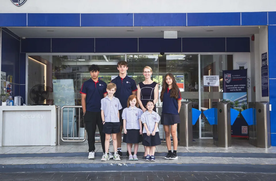 Students of different ages standing together at the school entrance